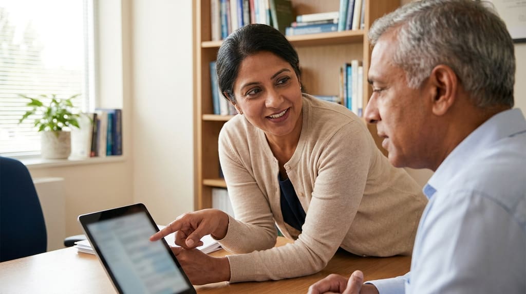 A dermatologist in soft clothing having a calm conversation with a patient in a warm office